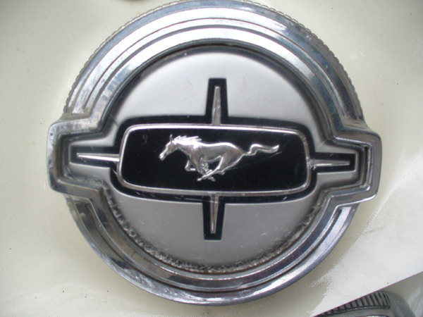 1968 Ford Mustang emblem on cream-colored body