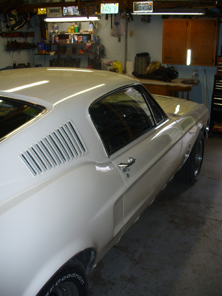 1968 Ford Mustang - A white 1967 Ford Mustang coupe is parked in a garage, showing its distinctive side vents.