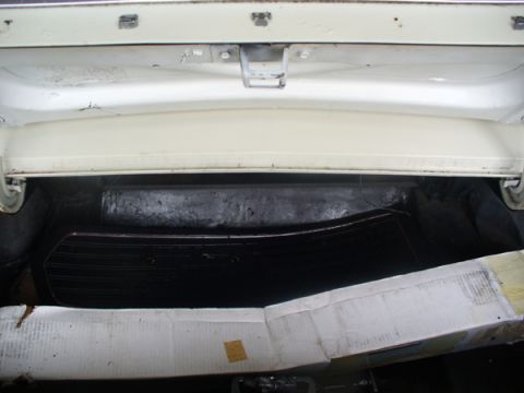1968 Ford Mustang - The interior of a car's trunk is shown, revealing a black mat and a cardboard box.