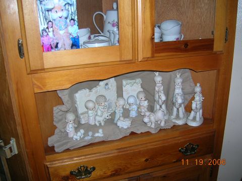 1985 Ford Bronco - A wooden cabinet displays a nativity scene and a framed photograph of children with the Easter Bunny, dated 11.19.2006.