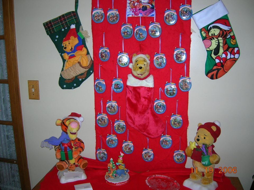Christmas stocking with Pooh, Tigger plush, and ornaments on a red display
