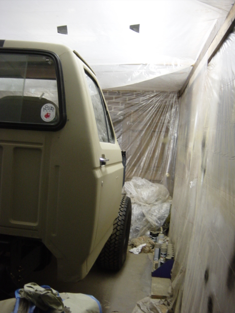 1991 Ford Bronco - Rear view of a tan Ford Bronco, possibly undergoing work in a covered area.