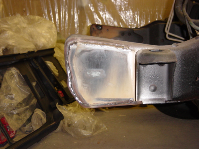 Close-up of a vehicle frame section undergoing repair, showing metalwork and welds