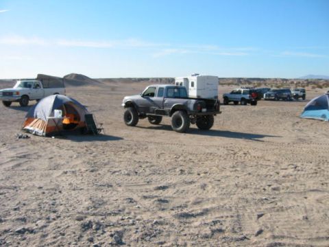 1997 Ford Ranger - Several trucks and tents are set up in a desert area under a clear blue sky.