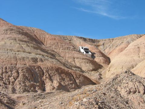 1997 Ford Ranger - Pickup truck navigates a challenging off-road path through a desert landscape.