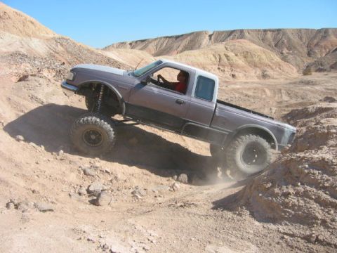1997 Ford Ranger - A modified 1997 Ford Ranger navigates a steep, dusty incline in a desert landscape.