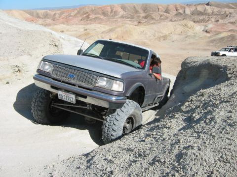 1997 Ford Ranger - A modified Ford Ranger navigates a steep, sandy incline in a desert landscape.