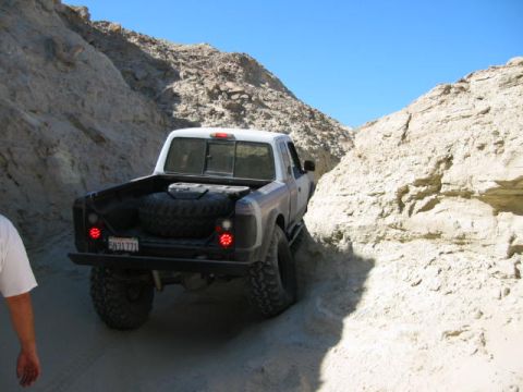 1997 Ford Ranger - A 1997 Ford Ranger navigates a narrow, sandy off-road trail between steep rock formations.