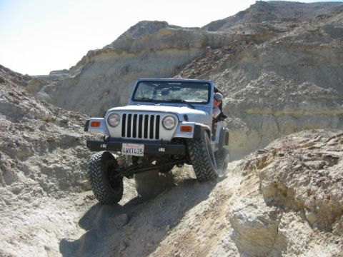 1997 Ford Ranger - A Jeep Wrangler navigates a challenging off-road path in a desert canyon.