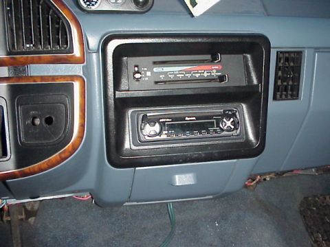 1989 Ford Bronco - Center dash stack of a blue-gray Ford truck interior showing the slide-lever heater and A/C control panel above an aftermarket CD head unit…
