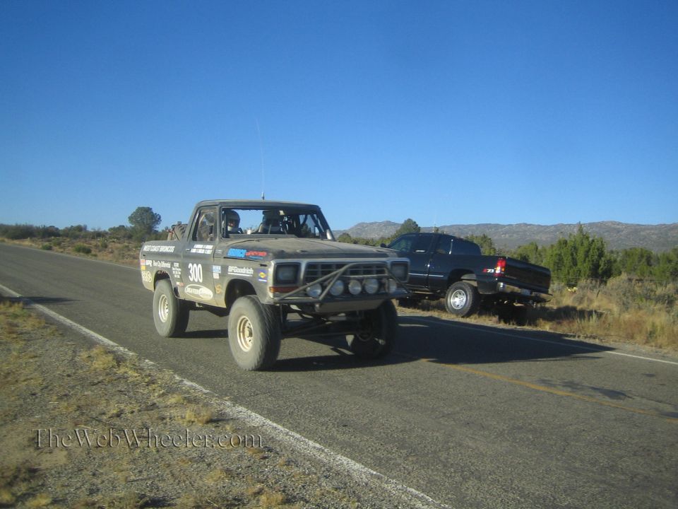 Vintage Ford bronco-style off-road race truck number 300 on a desert highway
