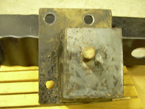 1978 Ford Bronco - Close-up of a used engine motor mount part, showing wear and metal construction.