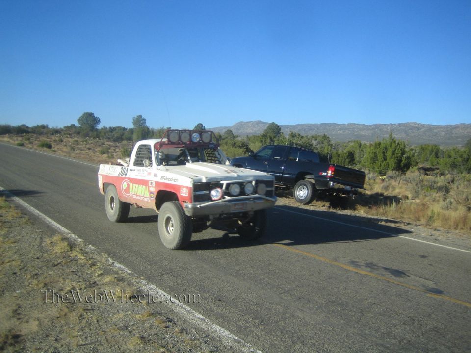 White and red 1970s Chevrolet race pickup on a desert highway