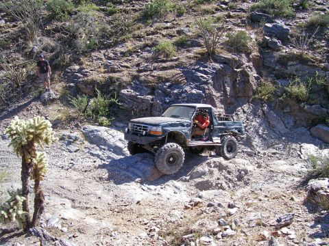 1991 Ford Bronco - A modified pickup truck tackles a challenging off-road course in a dry, rocky environment.