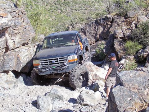 1991 Ford Bronco - A Ford Bronco navigates a challenging rocky terrain, demonstrating its off-road capabilities.
