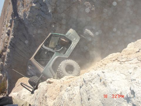 1996 Ford Bronco - Off-road vehicle stuck on a steep, dusty, rocky incline, kicking up dust.