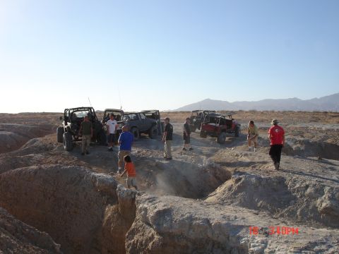 1996 Ford Bronco - Group of off-road vehicles and people gathered in a desert landscape.