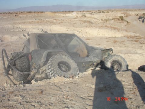 1996 Ford Bronco - Off-road vehicle is stuck in a deep dirt ditch with large tires.