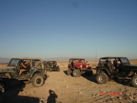 1996 Ford Bronco - A group of Jeeps are gathered in a desert environment on a sunny day.