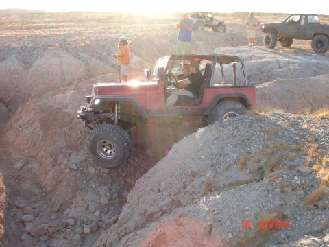 1996 Ford Bronco - Off-roading adventure with a red Jeep Wrangler navigating a challenging course in a desert landscape.
