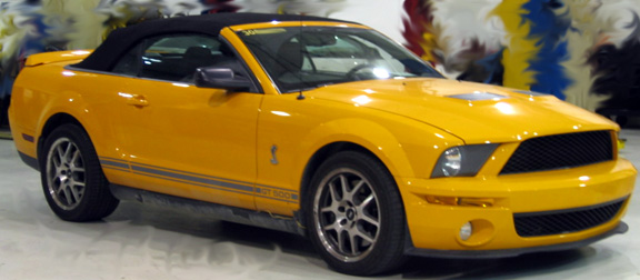 Yellow convertible with black top and side stripes. Text reads 'GT 500'
