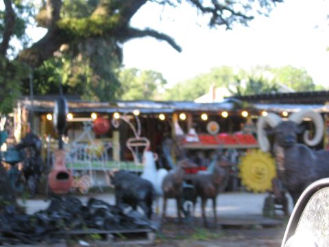 1974 Ford F-100 - A blurry outdoor scene shows various sculptures and a building with decorative lights.