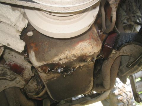 1990 Ford Bronco - The oil pan on this vehicle shows significant leakage and grime, indicating potential maintenance issues.