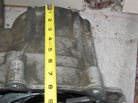 1991 Ford Bronco - Measuring an engine oil pan with a tape measure.
