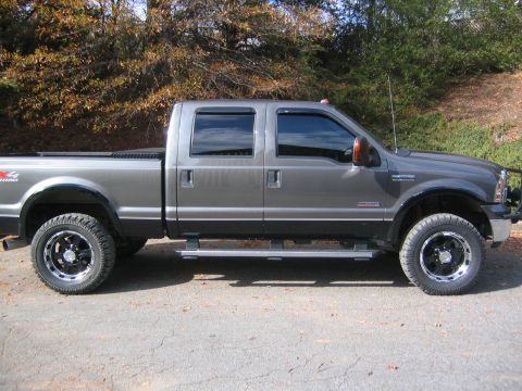 2005 Ford F-250 - Side profile of a grey 2005 Ford F-250 Super Duty pickup truck with aftermarket wheels and tires.