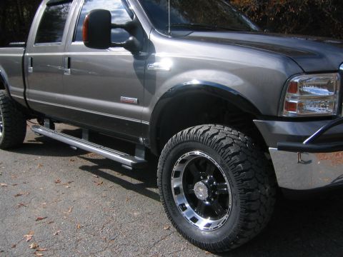 2005 Ford F-250 - This gray pickup truck features custom wheels and tires, enhancing its appearance.