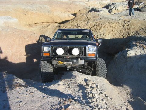 1985 Ford Bronco - This 1985 Ford Bronco is navigating a challenging off-road course with steep inclines and tight turns.