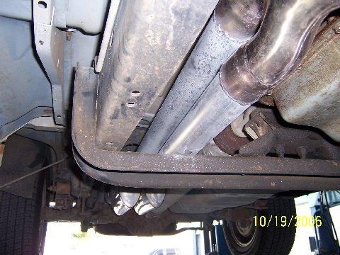 1991 Ford Bronco - The underside of a vehicle displays a custom dual exhaust system with visible date stamping.