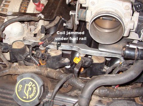1999 Ford Crown Victoria - The coil barely fits wedged between the extension & the fuel rail, which gives it the most strength to hold the spark plug down in the hole…