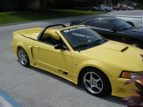 1978 Ford Mustang II - A yellow convertible with a "SALEEN" banner sits in a parking lot next to a black car.