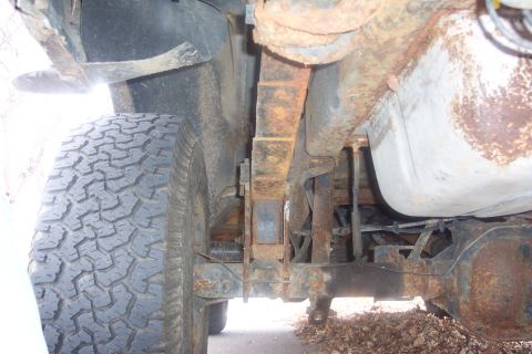 1990 Ford Bronco - Undercarriage view showing the rear leaf spring suspension and fuel tank of a vehicle.
