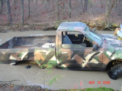 1992 Toyota Tacoma - This pickup truck, possibly a 1992 model, is stuck deep in the mud with a cracked windshield.