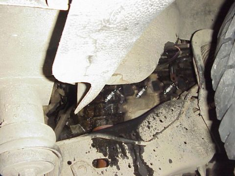 1989 Ford Bronco - Undercarriage view reveals suspension components and engine parts, with a tire visible on the right.