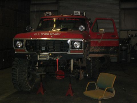 1979 Ford Bronco - This red 1979 Ford Bronco is on jack stands for maintenance, a winch and lifted suspension.