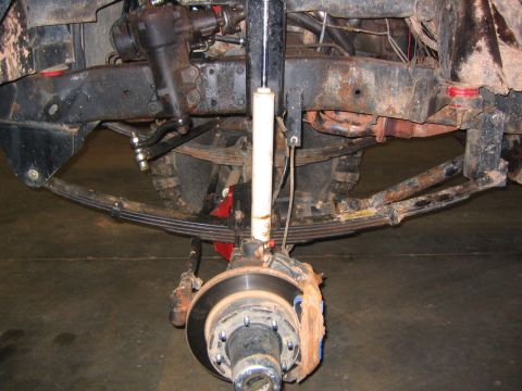 1979 Ford Bronco - Close-up view of the front suspension and steering system of a vehicle, showing its mechanical components.