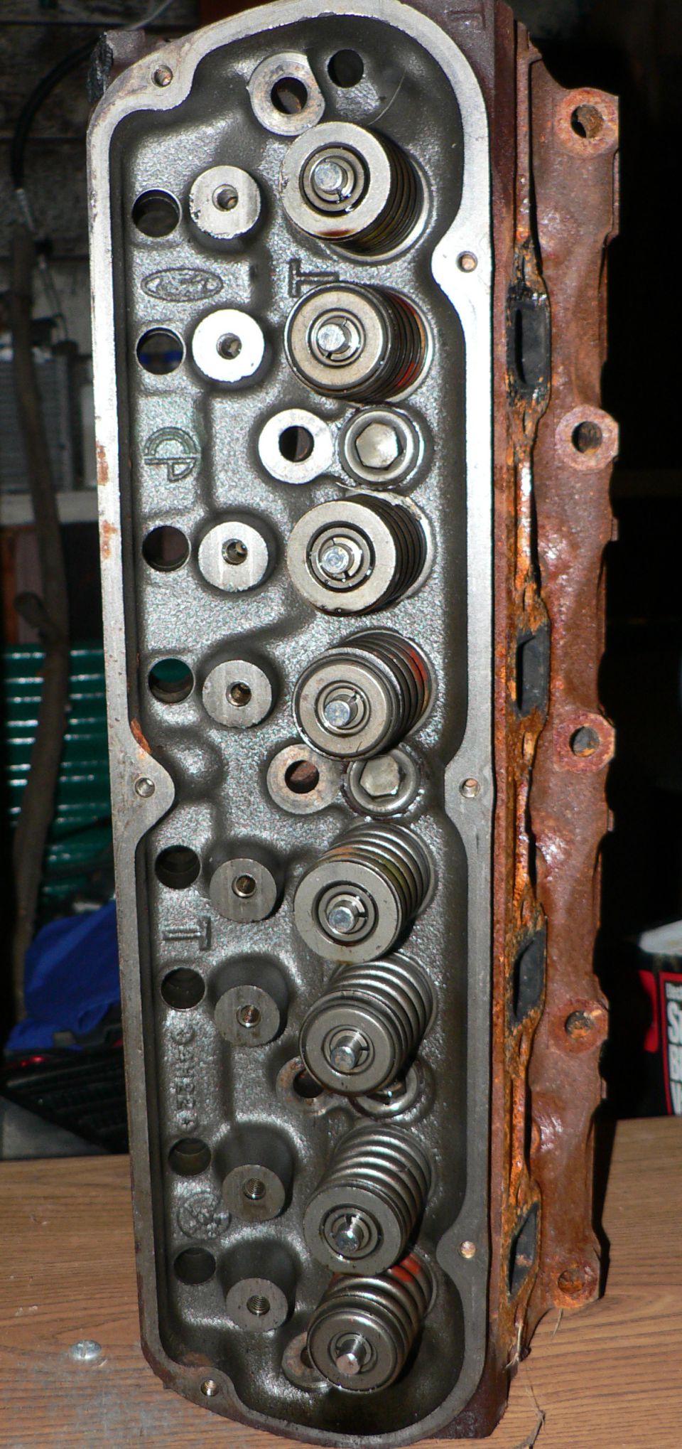 Ford cylinder head on bench with valve springs, rocker studs and cast Ford oval