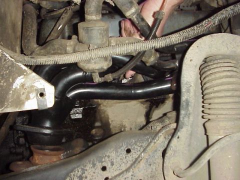 1989 Ford Bronco - Close-up view of an engine's exhaust manifold and associated plumbing.