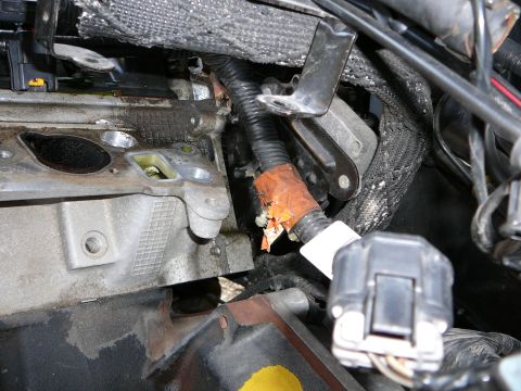 1997 Mercury Grand Marquis - Close-up of a bare cylinder head deck on an engine still in the car, with the intake side machined surface, a green plastic locator/dowel s…