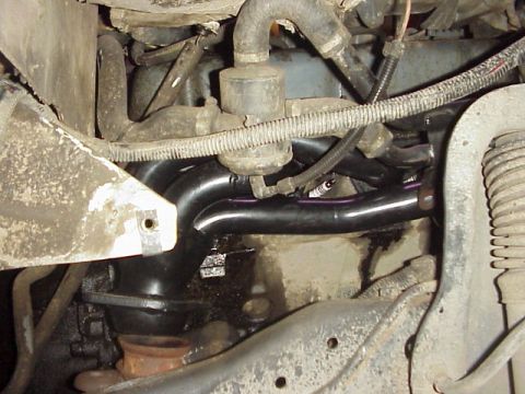 1989 Ford Bronco - Close-up view of an engine's exhaust manifold and associated components.