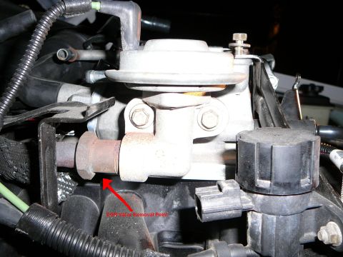 1997 Mercury Grand Marquis - Close-up of an EGR valve mounted in an engine bay, with a red arrow and the annotation "EGR Valve Removal Point" pointing at the rusty tube…