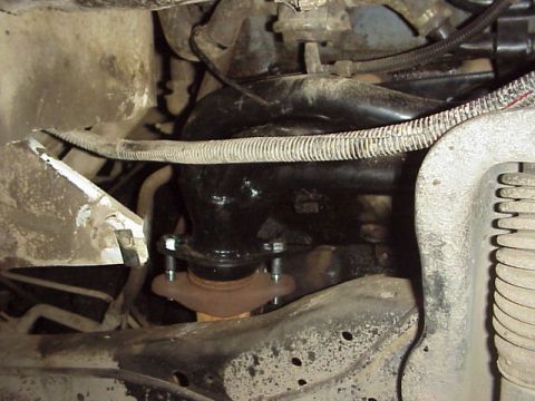 1989 Ford Bronco - Close-up view of an engine's exhaust manifold and pipe connection.