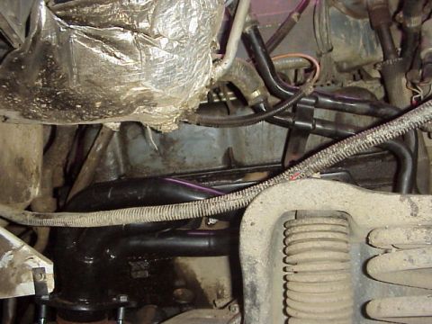 1989 Ford Bronco - Engine compartment detail showing exhaust manifold, hoses, and wiring harness.