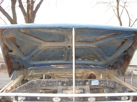 1977 Ford F-150 - Underside of the hood and engine bay of a 1977 Ford F-150, with visible rust.
