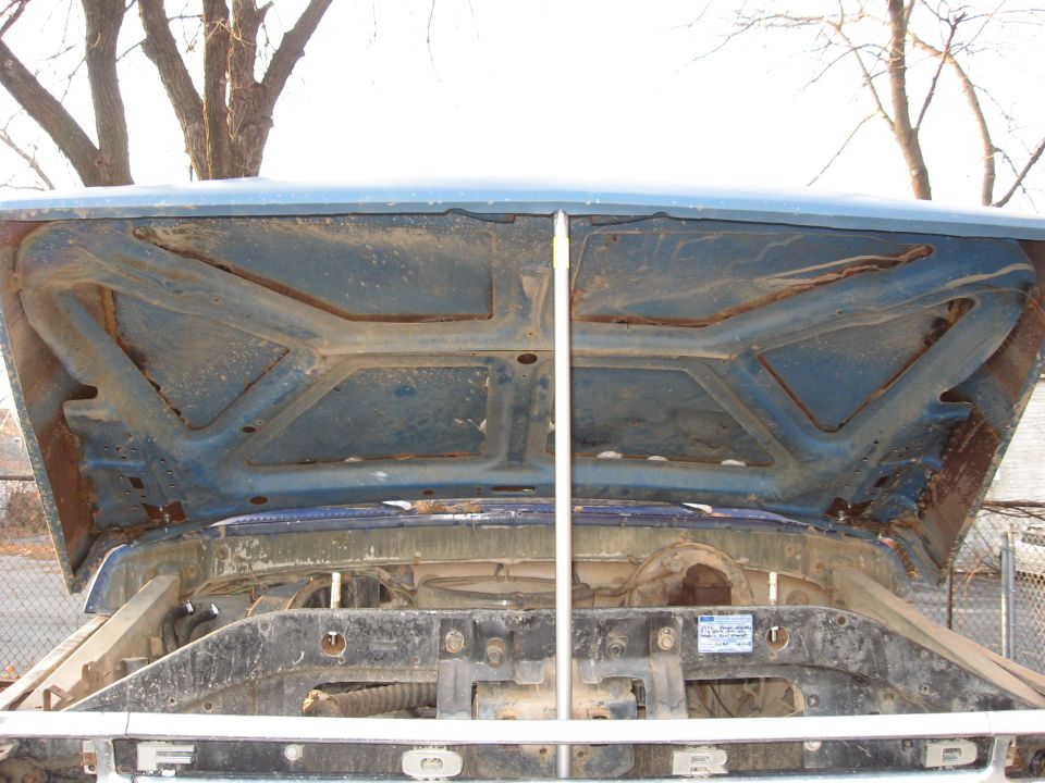 1977 Ford F-150 hood underside and engine bay, showing some rust and dirt