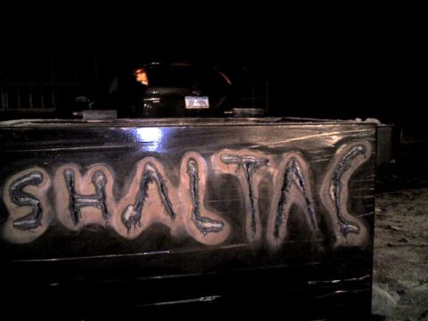 1987 Ford Bronco - A black sedan is visible in the background at night, with prominent lettering on a foreground object.