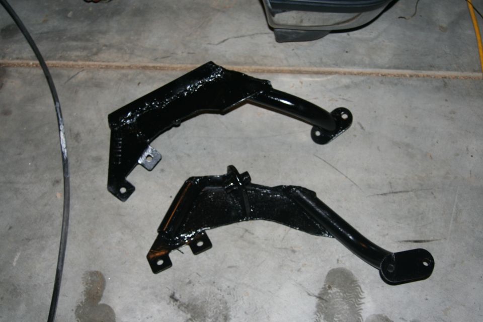 Two black suspension brackets on concrete floor